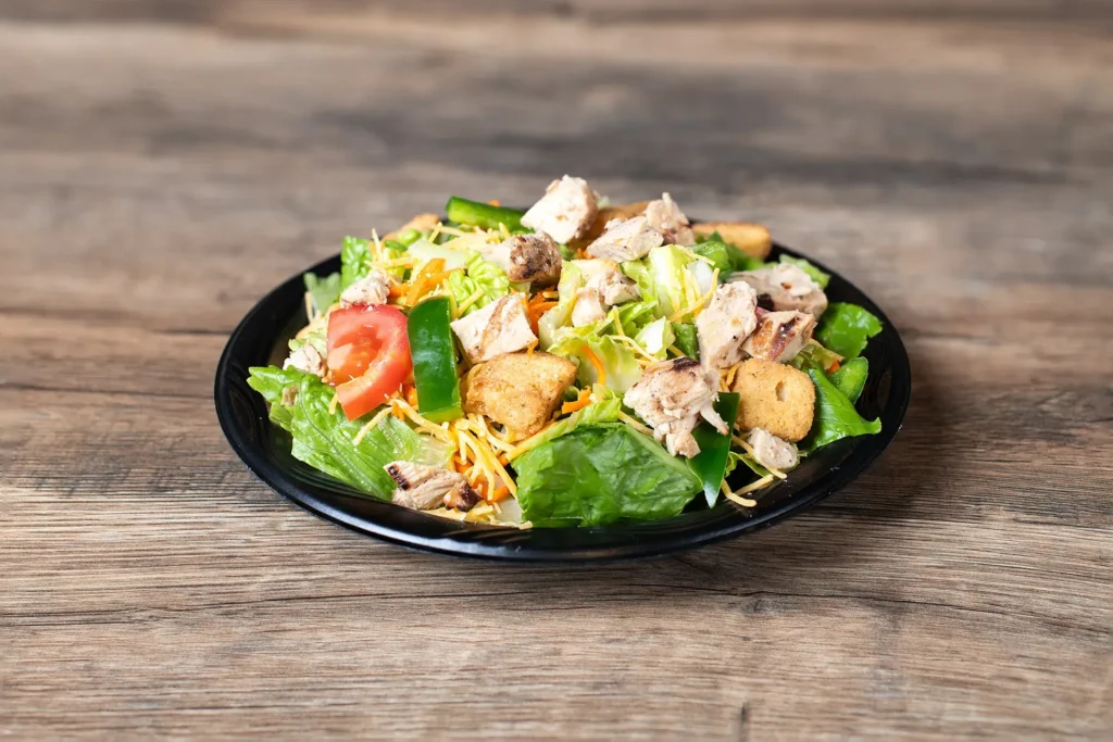 Staleys salad on a plate placed on a wooden table.