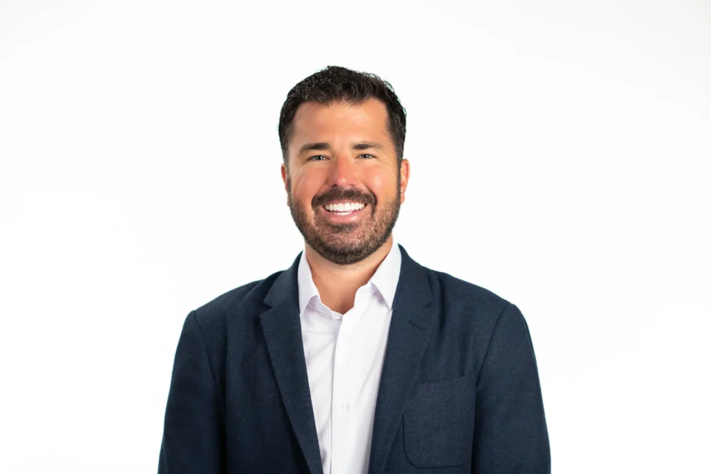 Professional headshot of a man against a white background