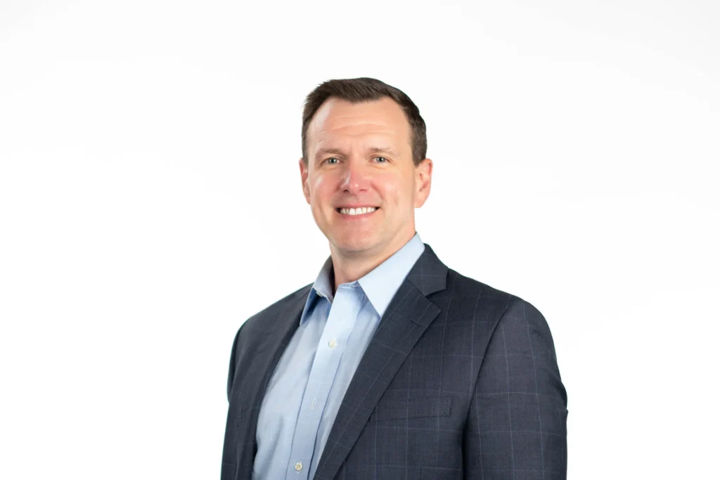 Professional headshot of a man against a white background