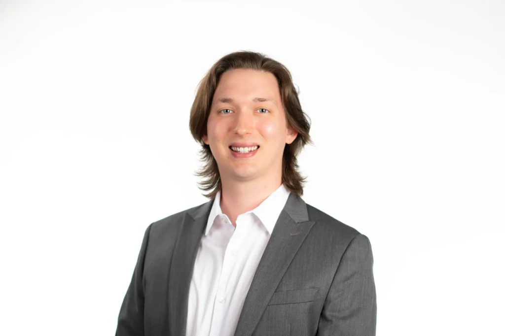 Professional headshot of a man against a white background