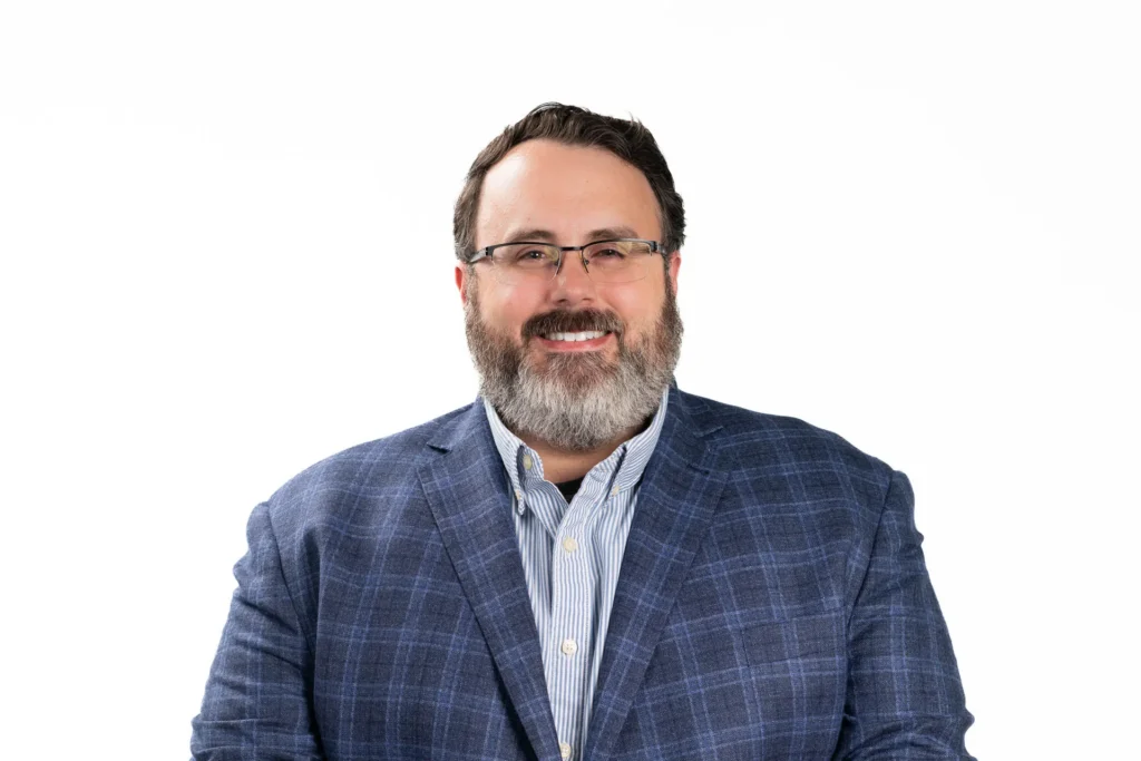 Professional headshot of a man against a white background