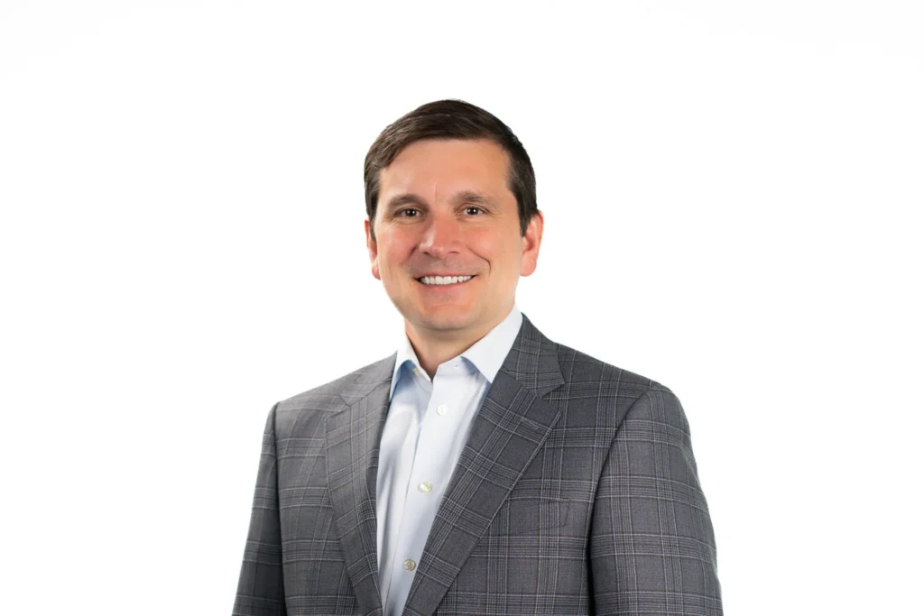Professional headshot of a man against a white background
